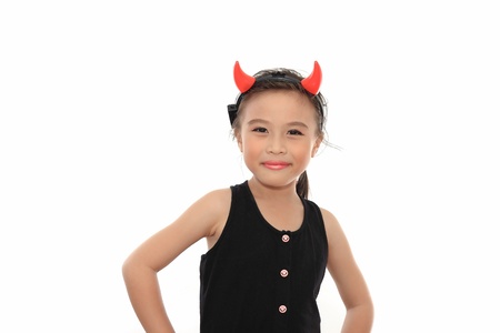 Scary cute little asian girl in black Halloween costume.の写真素材