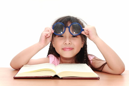 Asian little girl reading a book isolated on a over white backgroundの写真素材