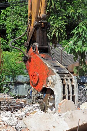 Closeup Heavy excavator Destroyed the buildingの写真素材