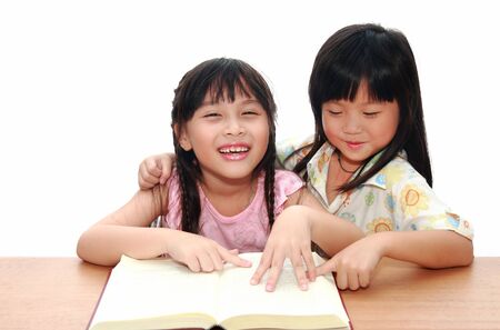 Intelligent little girl  reading a bookの写真素材