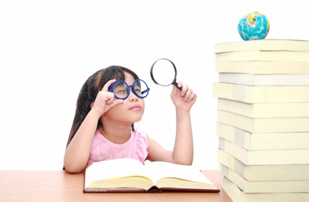 Intelligent little girl  reading a bookの写真素材