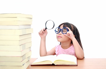 Intelligent little girl  reading a bookの写真素材