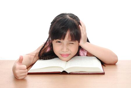 Intelligent little girl  reading a bookの写真素材