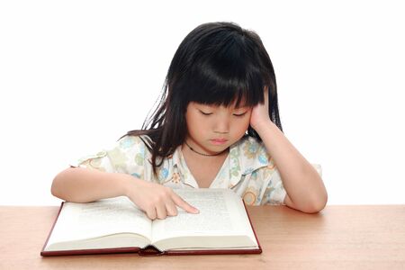 Intelligent little girl  reading a bookの写真素材