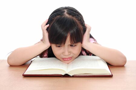 serious little girl  reading a bookの写真素材