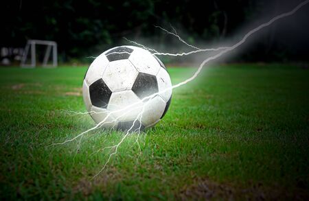 Football on green grass with lightningの写真素材
