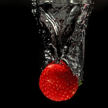 strawberry splashing into waterの写真素材