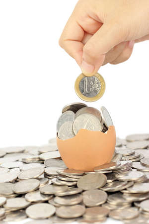 hand keep euro coin on broken eggshellの写真素材