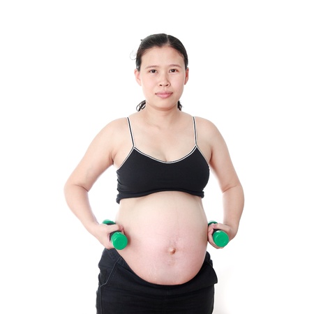 Pregnant woman exercising with dumbbells isolated on white backgroundの写真素材