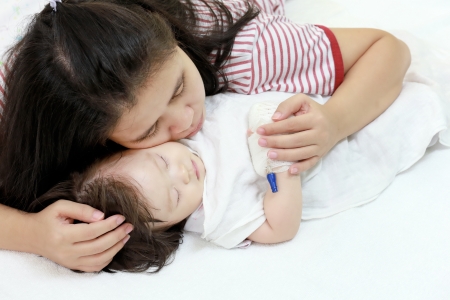 Sick child in her mother's arms.の写真素材