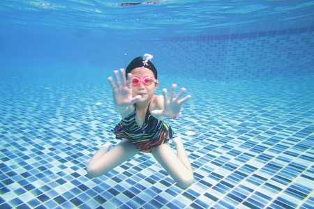 little asian girl underwater in swimming poolの写真素材
