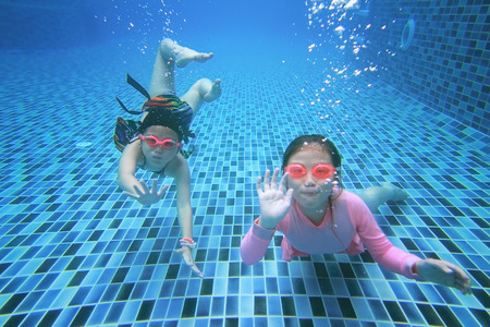 little asian girl underwater in swimming poolの写真素材