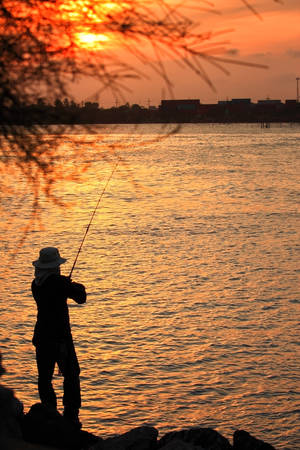 Fisherman silhouette at sunsetの写真素材