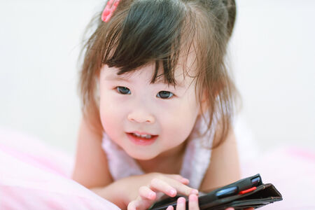 little girl using mobile phoneの写真素材
