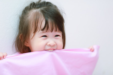 little girl bite a fabricの写真素材