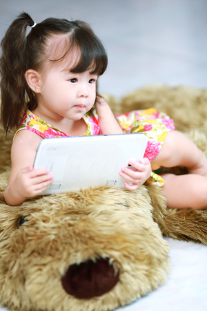 Happy baby girl using tablet computerの写真素材