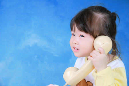 Portrait of little girl with retro phoneの写真素材
