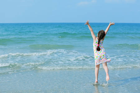 Happy little girl on the beachの写真素材