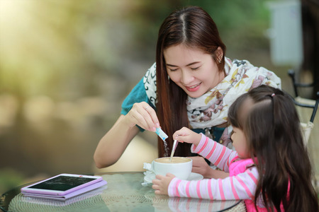 Young mother relaxing together with her little child  girl in summer outdoorsの写真素材