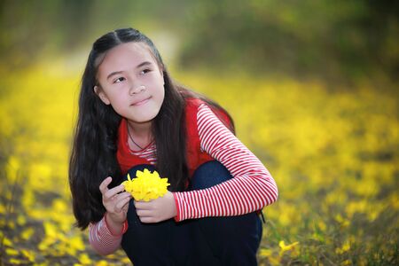 Beautiful girl holding a flower in her handの写真素材