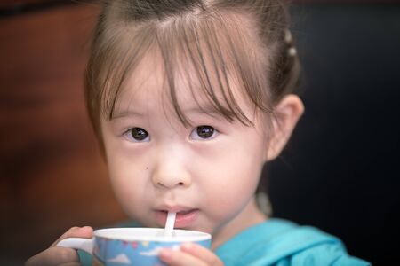 little girl drinking juicesの写真素材