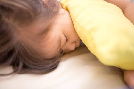 asian little girl sleeping on the bedの写真素材