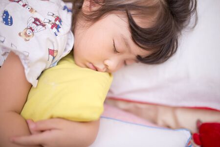 asian little girl sleeping on the bedの写真素材