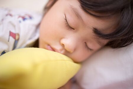 asian little girl sleeping on the bedの写真素材