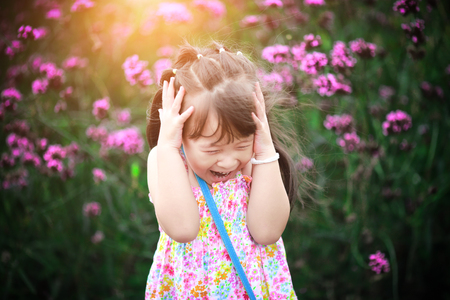 Happy little girl in flower fieldの写真素材