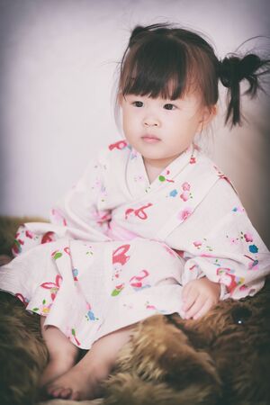 Asian little girl wearing kimono vintage filterの写真素材