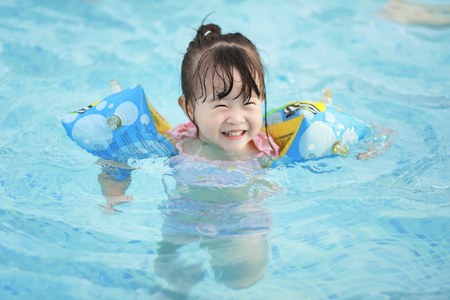 asian little girl in swimming poolの写真素材