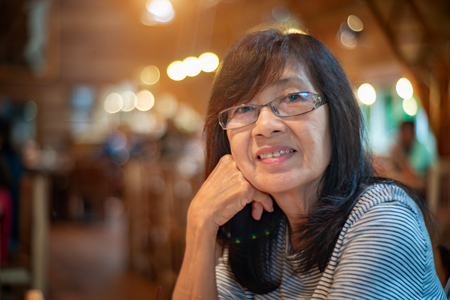 senior woman sitting in restaurantの写真素材