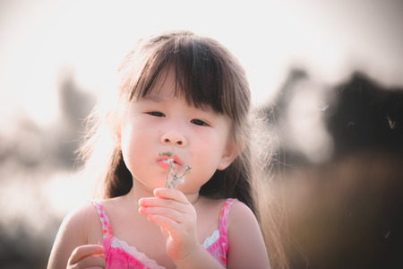 little girl blowing dandelionの写真素材