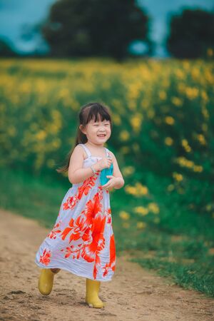 Happy little asian girl in flower fieldの写真素材
