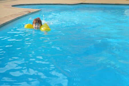 asian little girl in swimming poolの写真素材