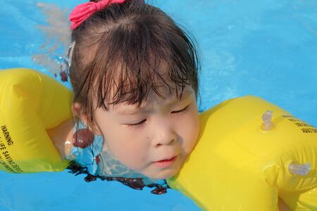 asian little girl in swimming poolの写真素材