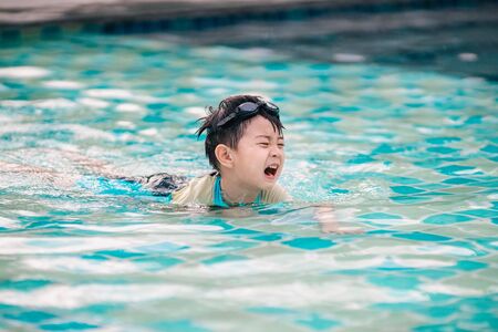 The boy is crying in swimming poolの写真素材
