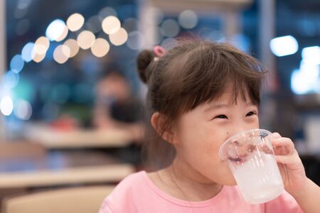 Little asian girl drinking waterの写真素材