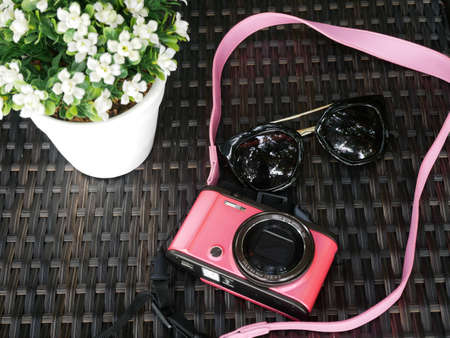 Pink camera and sunglasses on the table