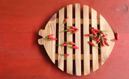 Red chili pepper on wooden chopping blockの写真素材