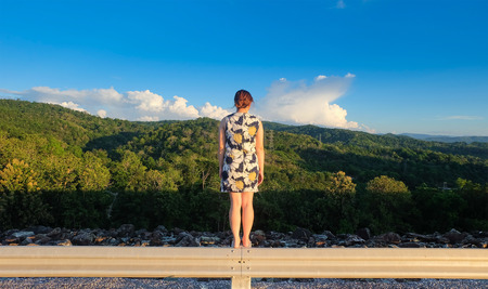 Girl stand back with nature landscape before sunsetの写真素材