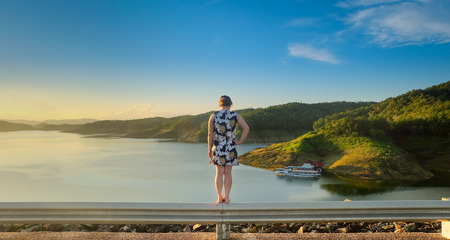 Girl stand back with nature landscape before sunsetの写真素材