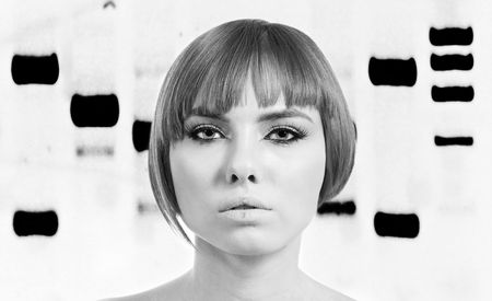 Beautiful face of an engineered bionic woman in front of a genetic DNA banding pattern of electrophoresis, black and white.の写真素材