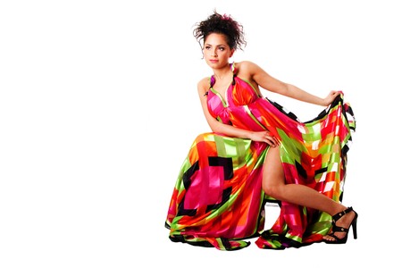 Beautiful Caucasian Hispanic Latina fashion model woman wearing colorful dress, sitting, isolated.の写真素材