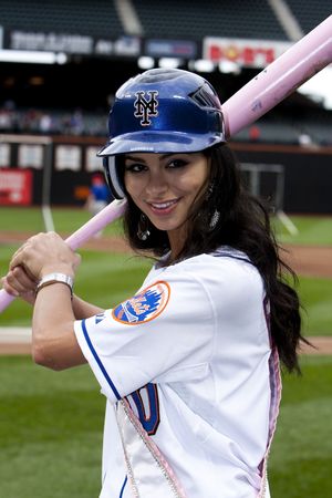 New York - 27 May 2010: Miss USA, Rima Fakih, wearing jersey, holding pink bat and blue cap at the Mets vs. Phillies baseball game in Citi Field Park stadium, New York.のeditorial素材