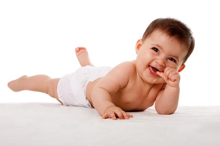 Happy cute baby laying with thumb in mouth, isolated.の写真素材