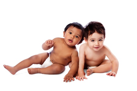 Two cute adorable multi-ethnic babies sitting together, childhood concept, on white.の写真素材