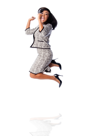 Beautiful happy jumping cheering business woman celebrating joyfully, on white.の写真素材
