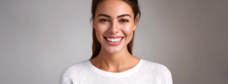 Portrait of smiling young woman with healthy teeth in white sweaterの素材