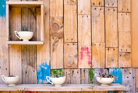 Wooden wall decoration with shelves and vases cup with flowersの写真素材